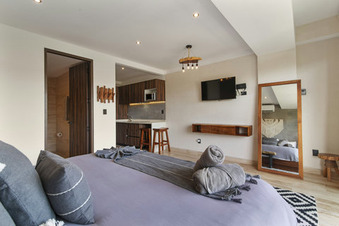 Experience luxury in this modern bedroom with a plush bed, elegant wood furniture, and serene ambiance. Perfect for a restful guest retreat!