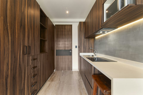 Cook and unwind in a modern kitchen filled with natural light, premium appliances, and warm wooden accents—ideal for long or short stays.
