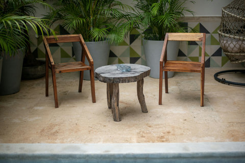 Relax by the pool with this cozy patio set, surrounded by tropical plants and rustic charm.