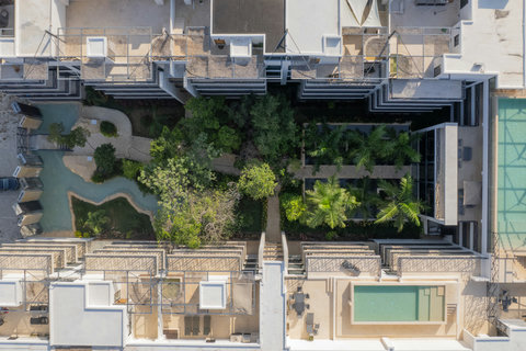 Aerial view of a lush garden courtyard framed by modern architecture and serene walkways.