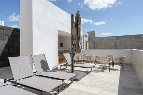 Stylish shared rooftop with sun loungers, umbrellas, and poolside seating. Ideal for relaxing, soaking up the sun, or enjoying a tranquil afternoon with open sky views.