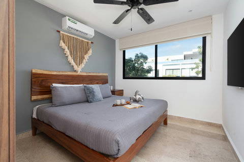 Spacious master suite featuring a king-size bed, Smart TV, A/C, blackout curtains, and a work desk. A perfect blend of comfort, elegance, and functionality for a restful and productive stay.