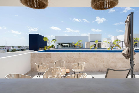 Stylish shared rooftop with a modern design, sleek pool, and tropical details. Perfect for soaking up the sun, enjoying the breeze, and taking in open, relaxing views.