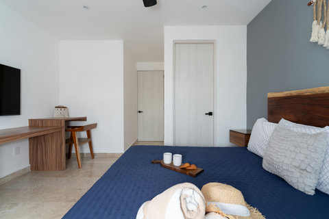 Bright and spacious master bedroom featuring a king-size bed, Smart TV, A/C, blackout curtains, and a sleek work desk. Perfect for restful nights and productive mornings in total comfort.