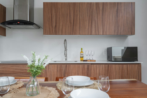 Modern kitchen featuring sleek wooden cabinetry, stainless steel appliances, and elegant finishes. Perfectly equipped for cooking and sharing meals in a warm, contemporary setting.