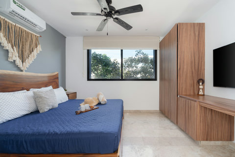 Inviting master suite featuring a king bed, Smart TV, A/C, and a sleek wooden desk. The perfect blend of comfort and functionality, ideal for restful nights and productive mornings.