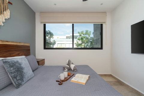 Elegant master bedroom featuring a king-size bed, A/C, Smart TV, blackout curtains, spacious closet, and a desk—perfect for restful nights and focused work during your stay.