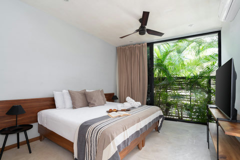 A serene bedroom with a comfortable king bed, soft natural light, and lush garden views—perfect for relaxing and recharging.