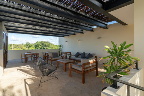 Relax in this open-air terrace featuring cozy wood furniture, soft seating, and peaceful views—perfect for unwinding or enjoying a quiet morning coffee.