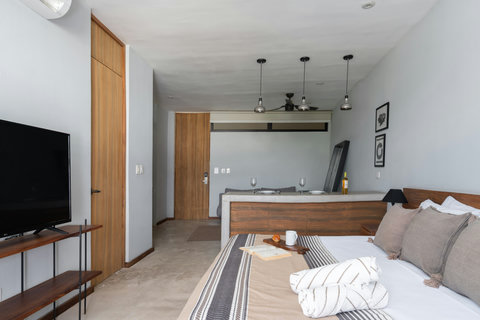 This bright studio features a comfortable bed, stylish wooden touches, and a modern 50-inch TV. It creates a cozy, contemporary atmosphere where everything you need is right at your fingertips for a relaxing stay.