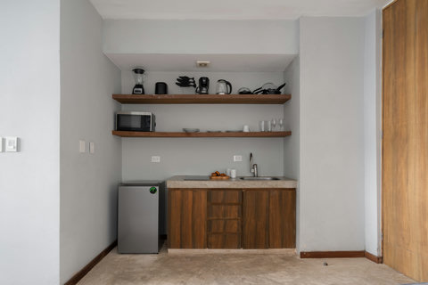 A small but well-equipped kitchen with everything you need for a great stay. It includes a fridge, coffee maker, hot water kettle, pots, pans, and more—perfect for simple meals and added convenience.