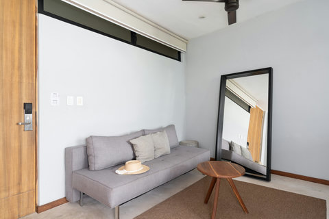 An elegant sofa, a large mirror, and a charming coffee table come together to create a warm and cozy lounge area. It’s a welcoming space perfect for relaxing, reading, or enjoying a quiet moment.