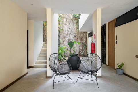 The lobby features elegant Acapulco chairs, creating a stylish and comfortable seating area. Perfect for relaxing, waiting, or enjoying a moment of calm in a chic, welcoming space.