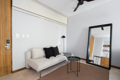 A cozy sofa paired with a large mirror and a stylish coffee table creates a warm and inviting lounge area. It’s the perfect spot to relax, read, or enjoy a quiet moment during your stay.