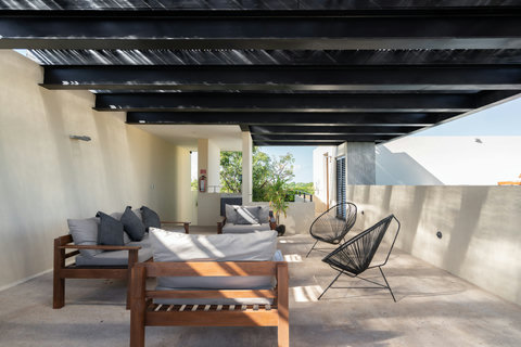 Relax in this inviting poolside lounge featuring comfortable chairs and a serene outdoor setting. Perfect for sunbathing, reading, or enjoying quiet moments, it offers a peaceful retreat to unwind.