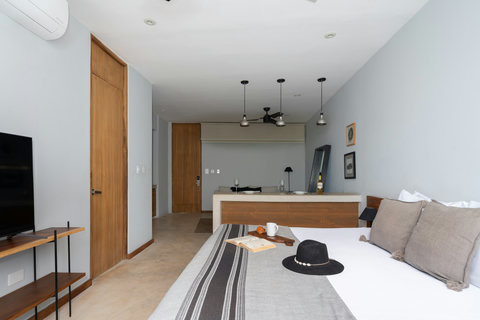 Enjoy a bright studio featuring a comfortable bed, elegant wooden accents, and a sleek 50-inch TV. This warm, modern space keeps all essentials within reach for a relaxing and convenient stay.