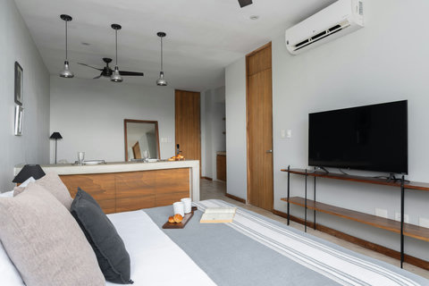 A contemporary studio with a cozy king bed, AC, elegant wooden details, and a 50-inch TV, offering comfort, style, and a welcoming atmosphere for your visit.