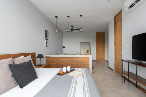 A modern studio with a comfy king bed, AC, elegant wooden details, and a 50-inch TV. Designed for comfort, style, and a relaxing, welcoming atmosphere.