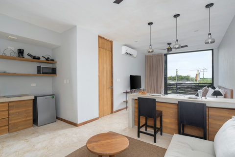 Enjoy a bright studio with a cozy living area, spacious dining island, and calming tropical views. Perfect for relaxing and unwinding in a fresh, modern space.