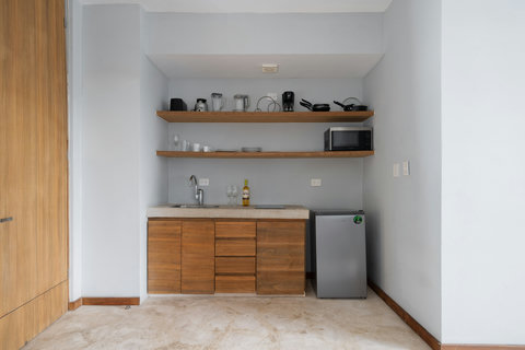 This cozy kitchen comes fully equipped with a fridge, stove, cookware, and coffee maker, offering comfort and ease for cooking and meal preparation.