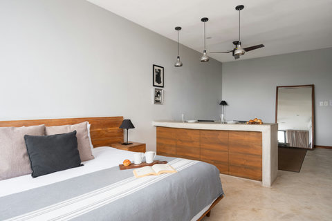 This modern studio offers a cozy king-size bed, air conditioning, stylish wooden accents, and a 50-inch TV. A bright and inviting space designed for comfort, convenience, and relaxation.