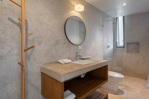 A stylish bathroom featuring a modern sink, large mirror, and a refreshing rain shower. Designed for comfort, relaxation, and an effortless daily routine.