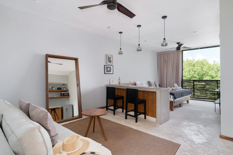 Enjoy a bright, modern open-plan living area featuring a cozy dining bar and calming views of lush greenery. It’s the perfect setting for relaxing, working, or unwinding in total comfort.