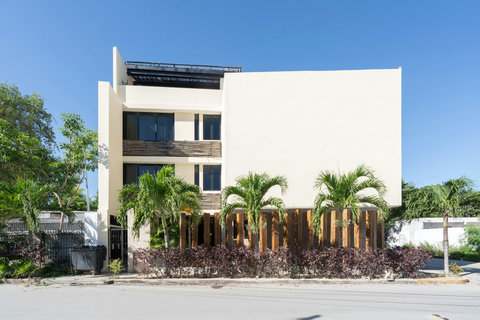 This elegant façade blends modern design with tropical charm, featuring natural textures and warm details that create a welcoming, refreshing, and stylish outdoor impression.