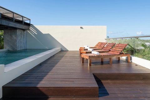 Relax on this bright rooftop terrace featuring cozy sunloungers, sparkling pool views, and a wide-open sky—perfect for soaking up the sun or enjoying quiet outdoor moments.