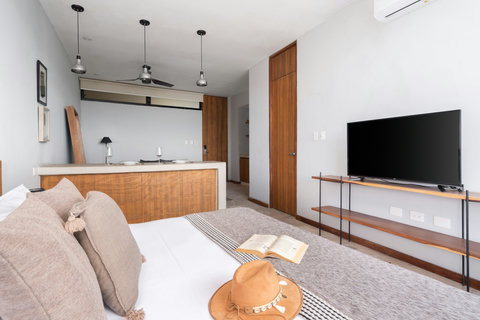 Relax in this luminous studio with a king-size bed, AC, chic wood details, and a 50-inch TV—a cozy, modern space with all essentials at your fingertips.