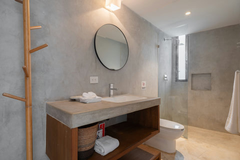 Relax in this warm, inviting bathroom featuring a soothing rain shower, bright mirror, and clean sink design—a perfect spot to refresh and unwind.