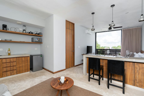 This integrated kitchen and dining space blends elegance and comfort, filled with sunlight and a cozy ambiance for cooking, relaxing, and enjoying meals.