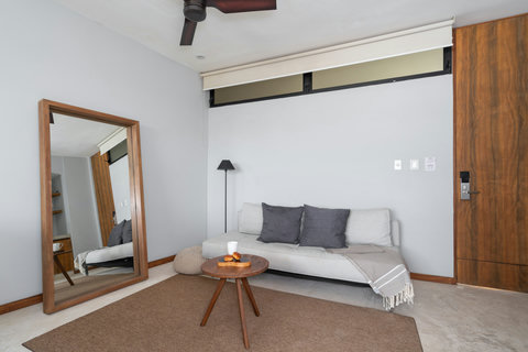 Relax in this charming area with a soft sofa, elegant coffee table, and large mirror—perfect for reading, lounging, or enjoying peaceful downtime.