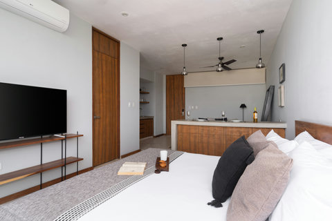 Relax in this bright studio featuring a cozy king bed, elegant wooden details, and a 50-inch TV—a stylish, comfortable space with everything at hand.