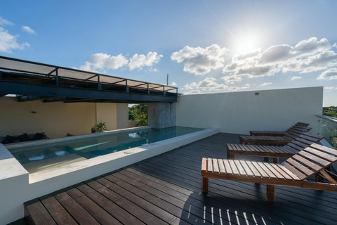 Enjoy the open-air rooftop pool with comfortable loungers and sweeping views—a serene spot to relax, unwind, and soak up the Tulum sun.