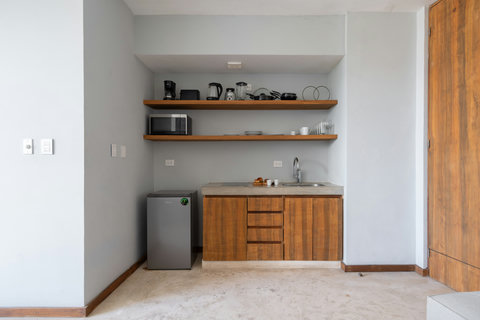 A well-equipped kitchen offering all essentials for effortless cooking, from a fridge and coffee maker to cookware and hot water kettle—perfect for a comfortable stay.