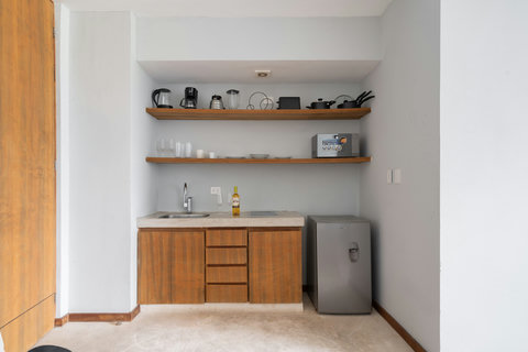 A well-equipped kitchen with a fridge, coffee maker, hot water kettle, and cookware—perfect for preparing simple meals and adding convenience to your stay.