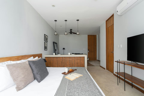 Enjoy a bright studio with a comfortable king bed, stylish wooden touches, and a 50-inch TV—a cozy, modern space designed for a relaxing and convenient stay.