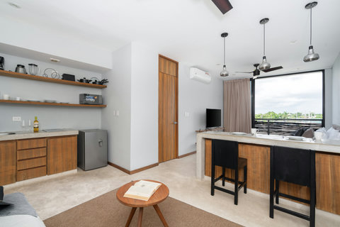 Enjoy a bright studio featuring a comfortable living area, spacious dining island, and calming tropical views—a fresh, modern space perfect for relaxing and unwinding.