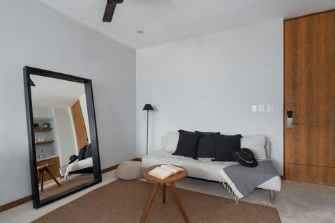A comfortable sofa, stylish coffee table, and large mirror create a warm lounge—ideal for reading, relaxing, or enjoying quiet moments during your stay.