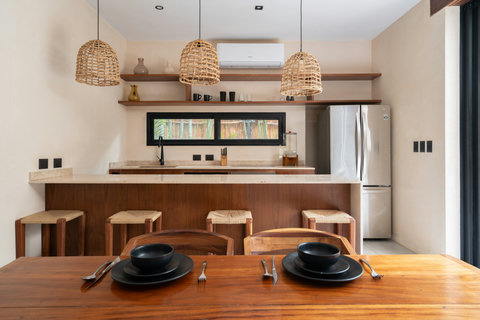 Beautifully designed kitchen bar featuring natural stone countertops, warm wood finishes, and handcrafted stools. Ideal for casual meals, morning coffee, or gathering in a relaxed, stylish atmosphere.