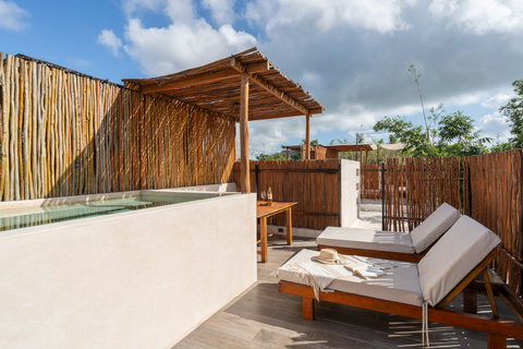 Enjoy a private rooftop sanctuary featuring a refreshing plunge pool, cozy lounge chairs, a small wooden table, and bamboo fencing. A peaceful tropical retreat, perfect for relaxing and soaking up the sun.