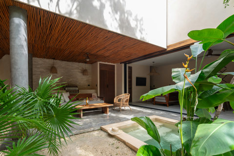 A beautifully designed outdoor lounge with a private pool, blending natural textures, warm wood ceilings, and cozy seating. An inviting space to relax, unwind, and enjoy peaceful tropical evenings in total comfort.