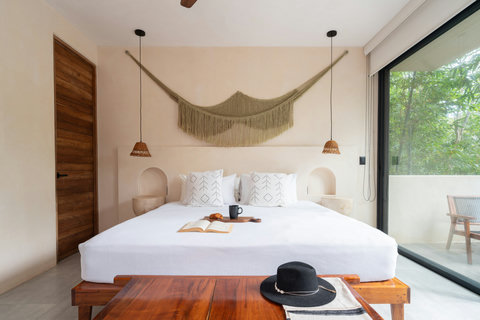 A luxurious king-size bed with plush bedding and organic textures, inviting relaxation, slow mornings, and truly restorative sleep.
