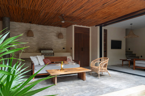 A beautifully designed outdoor lounge blending natural textures, warm wood ceilings, and cozy seating. The perfect space to relax, share a drink, or enjoy peaceful tropical evenings in comfort.