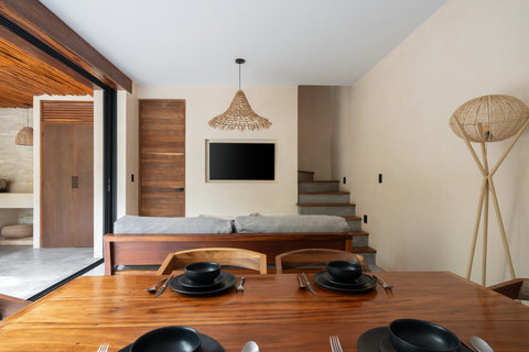 Relax in this modern living space featuring natural textures, wooden furniture, and soft neutral tones, creating a calm and inviting atmosphere perfect for unwinding or entertaining.