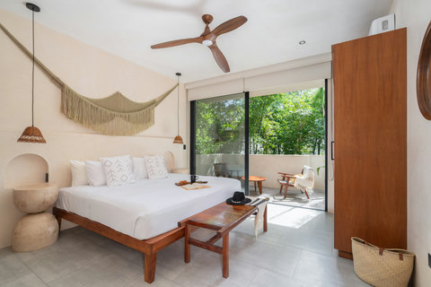 This tranquil bedroom blends minimalist design with warm, organic finishes. Enjoy a spacious king bed, calming décor, and seamless access to a private outdoor space surrounded by nature.