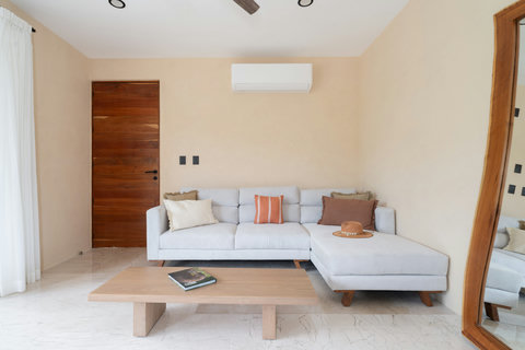 Cozy living room with a comfortable sectional sofa, soft neutral tones, and warm wood accents. A relaxing space designed for unwinding in style and comfort.