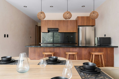 Modern kitchen with a spacious island, wooden finishes, and stylish lighting. Fully equipped and perfect for cooking, dining, and enjoying meals together.