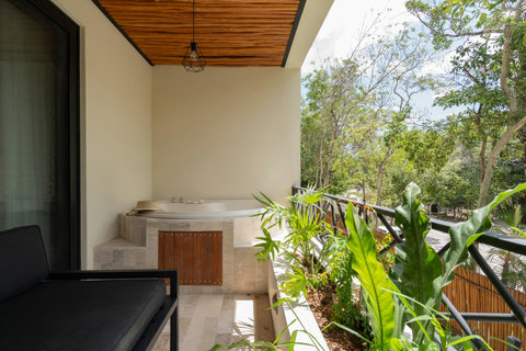 Private terrace with a relaxing jacuzzi, surrounded by lush greenery and natural light. A serene outdoor space perfect for unwinding and enjoying peaceful jungle views.